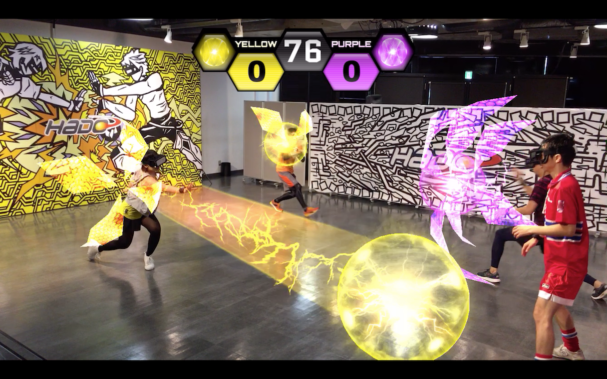 超人スポーツ協会の認定競技のひとつ「HADO®」。ヘッドマウントディスプレイとアームセンサーを装着したチーム同士が対戦し、エナジーボールとバリアで相手の体力を削っていく(写真提供:超人スポーツ協会)